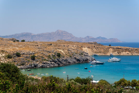 Lindos Beach surrounded by hills and blue water on a sunny day