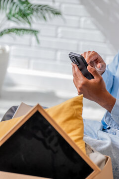 Hands using a mobile phone or smartphone looking for a moving or shipping app or service, moving and transport