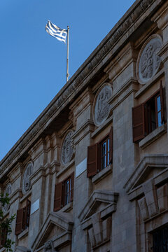 Greek flag flies above a historic building in Rhodes