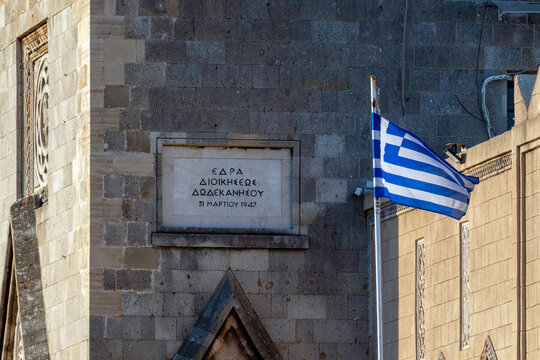 Building with a sign in Greek showing the date March 31, 1947 and a waving Greek flag