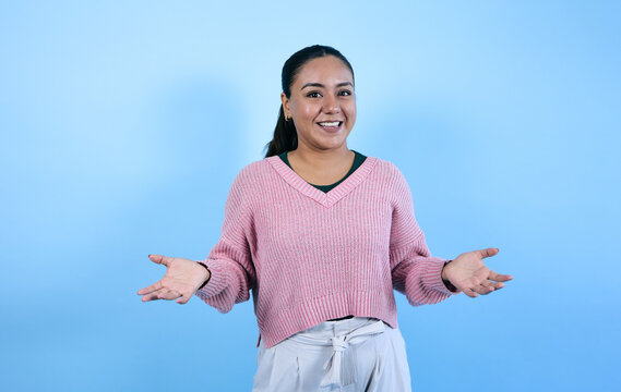 young mexican brunette woman on blue background in Mexico Latin America, portrait of latina girl with copy space 