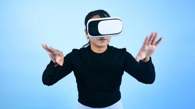 young Mexican woman using virtual reality glasses on blue background in Mexico Latin America, portrait of latina girl in technology concept