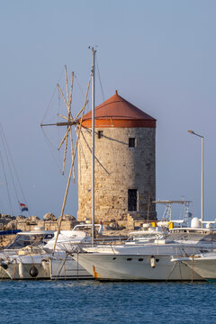 Windmill stands near the marina of Rhodes with boats