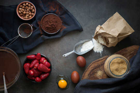 Overhead view of assorted Ingredients on a table for making a chocolate strawberry cake