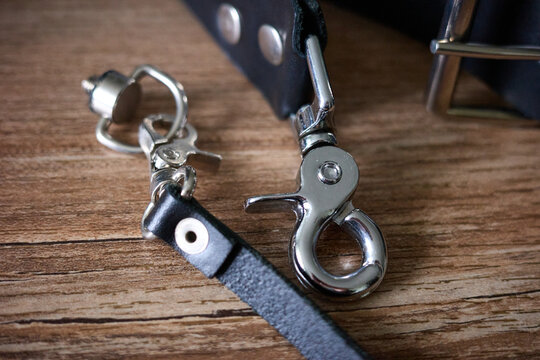 Details of a metal clip and strap on a wooden surface taken in close-up view in a well-lit room
