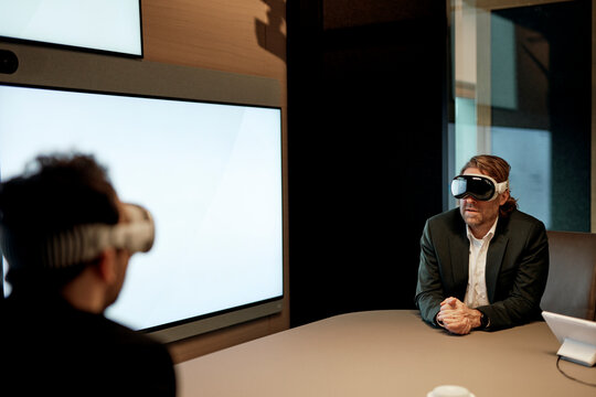 Businessman uses virtual reality headset in smart office meeting