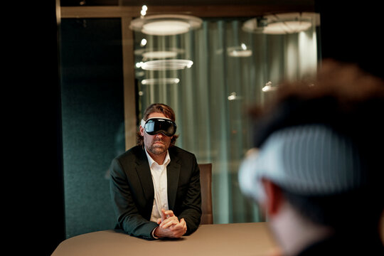 Businessman wearing virtual reality headset during office meeting