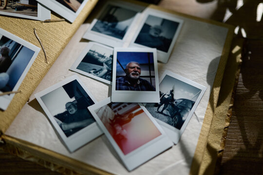 Old photographs on a table showing moments from different times and places