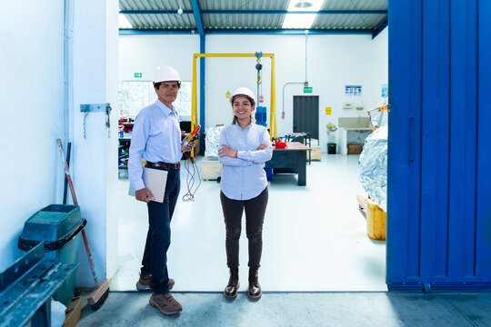 Man and woman technicians stand at the workshop entrance