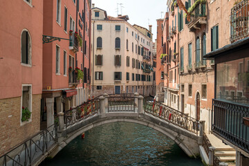 Historic Canal with Stone Bridge and Colorful Buildings in Venice, Italy