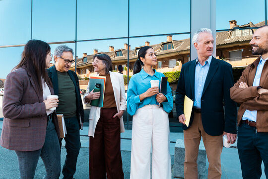 Business team discusses work during an outdoor morning coffee break