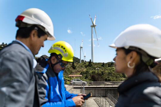 Engineers review renewable energy infrastructure at a wind farm