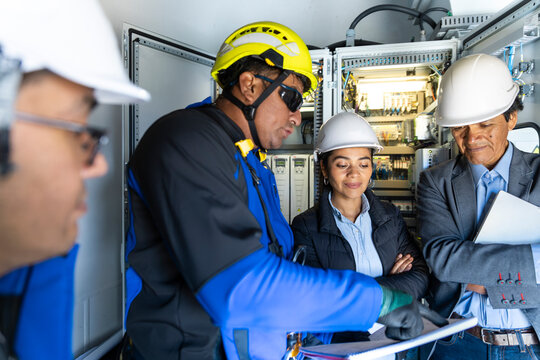 A team of engineers checks a document inside a wind turbine base