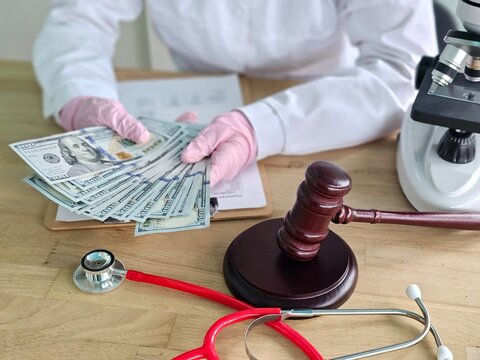 Money and legal tools in a medical setting show the link between healthcare