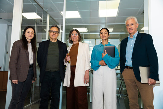 A business team stands confidently inside a modern corporate office