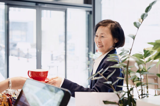 Businesswoman buys a coffee at a modern cafe