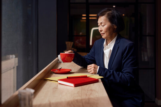 Businesswoman drinking coffee and working in a cafe