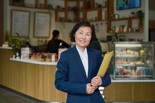 Smiling businesswoman holds a report in a coffee shop