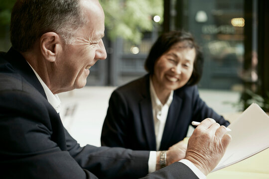 Businessman and businesswoman sign a contract at a cafe