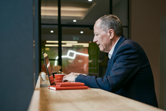 Businessman works on laptop at a coffee shop