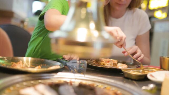 Mother and son eating together at a korean barbecue restaurant