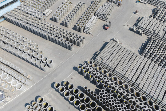 Aerial view of stacked concrete pipes and prefabricated elements at the Bruk-Bet manufacturing facility in Poland.