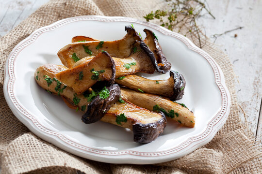 Plate of fried king trumpet mushrooms with thyme