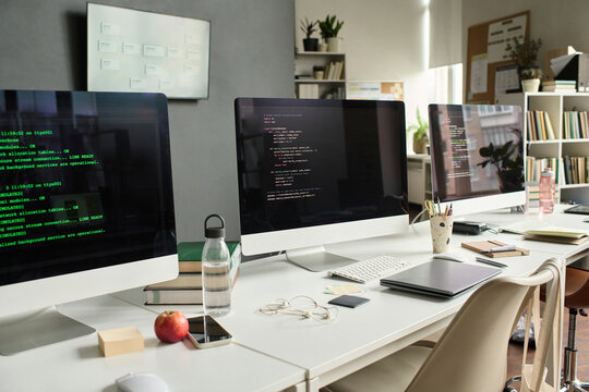 Empty classroom with programming code on computer monitor
