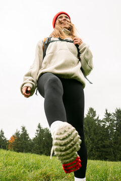 A smiling woman steps forward while hiking in the mountain forest
