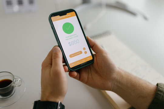 Male hands hold a smartphone showing a successful online payment