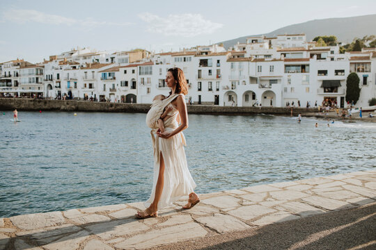 A mother walks with her baby along the waterfront in Cadaqu�s