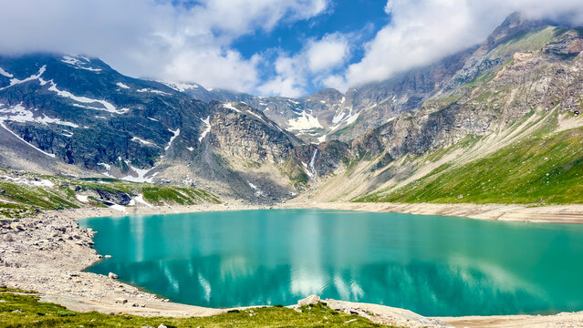 Turquoise Lake Serru reflects the mountains at Nivolet Pass in Italy