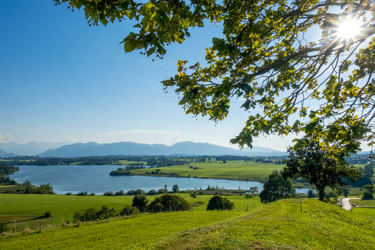 Riegsee lake landscape with sun rays and countryside in Bavaria