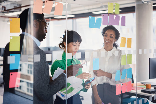 Colleagues brainstorm ideas on a glass wall in a London office