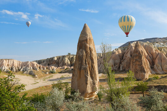 Turkey, Cappadocia, two hot air balloons hoovering over tuff rock formations at Goereme National Park