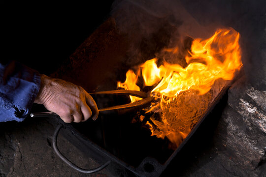 Germany, Bavaria, Josefsthal, burning hardening oil at historic blacksmith's shop