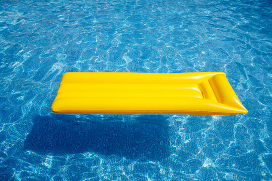 Yellow airbed floating in pool, elevated view