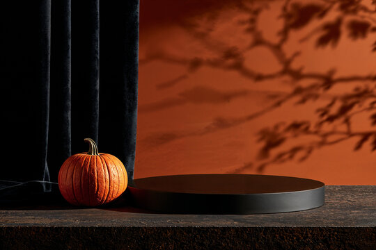 Pumpkin Beside Black Podium in Spooky Orange Scene