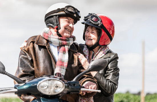 Happy senior couple riding motor scooter