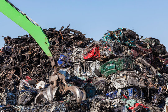Clamshell grabbing scrap metal of crushed cars