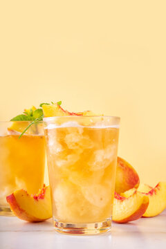 Summer cold drink, peach iced tea slushie cocktail. Shaved ice non-alcohol cold beverage, peach juice infused tea, copy space