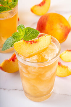 Summer cold drink, peach iced tea slushie cocktail. Shaved ice non-alcohol cold beverage, peach juice infused tea, copy space