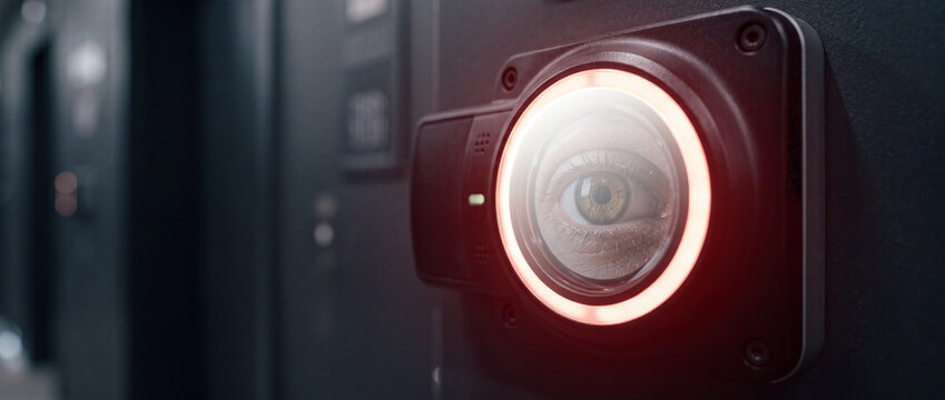 Close-up eye in biometric iris scanner security camera highlighting surveillance, access control and privacy concerns