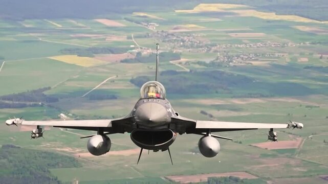 U.S. Air Force F-16 Fighting Falcon flies low above rural countryside during high-speed tactical training and readiness mission.