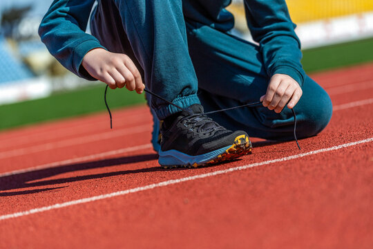 Hands tying shoelace on running shoes before practice. Sport active lifestyle concept. Laces, sneakers, hands. Runner getting ready for training