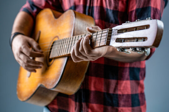Man's hands playing acoustic guitar, close up. Acoustic guitars playing. Guitarist on stage. Music lifestyle man playing guitar. Playing an acoustic guitar. Guitarist hands and guitar