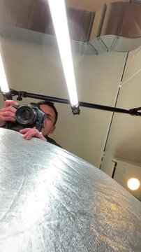 Interior low-angle shot showing two parallel fluorescent tubes and a round ceiling lamp against painted ceiling panels with exposed ductwork, cable tray and a