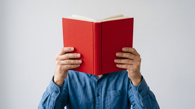 Person holding red book in front of face, symbolizing anonymous reader, education, study, knowledge, curiosity, and self learning.