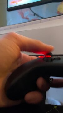 Thumb manipulating redtopped joystick on controller, responsive button taps captured in close perspective, practice session highlighting reflex