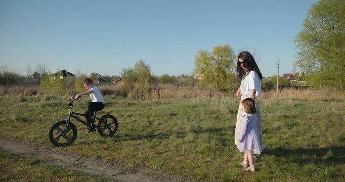 Children spend time with mother enjoying nature. 4K 10-bit
